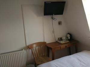 a bedroom with a desk with a television and a bed at Regency Hotel in Brighton & Hove
