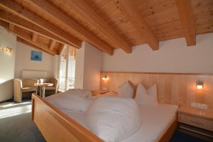 uma grande cama branca num quarto com tectos em madeira em Garni Dorfblick em Ischgl