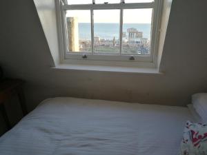 1 dormitorio con cama blanca y ventana en Regency Hotel, en Brighton & Hove