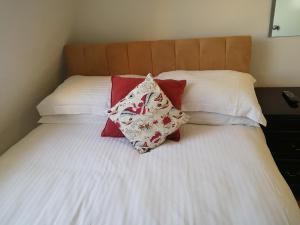 a bed with a white blanket and pillows on top of it at Regency Hotel in Brighton & Hove