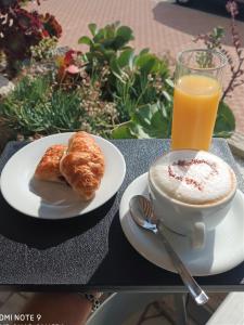 una taza de café, cruasanes y un vaso de zumo de naranja en Hôtel Le Dauphin en Menton