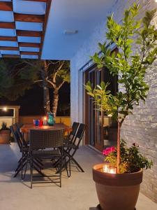 a patio with a table and chairs and a tree at Pine Tree Villa in Pakoštane