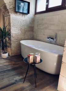 a bathroom with a tub and a table with boxes on it at Classe 51 - B&B con Jacuzzi - in Altamura