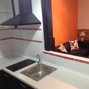 eine Küche mit einem Waschbecken, einem Fenster und einem Sofa in der Unterkunft Z45 Loft con Wifi en el Madrid Centro in Madrid