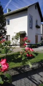 ein weißes Gebäude mit roten Blumen davor in der Unterkunft Appartement Veronika in Öblarn