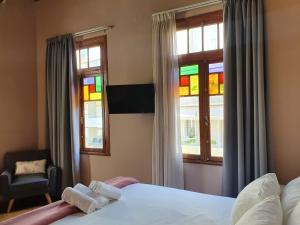 a bedroom with a bed and a window with stained glass at Porta Medina Boutique Hotel in Heraklio