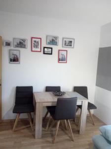 mesa de comedor con sillas y cuadros en la pared en Landhaus Tirol, en Presseggersee