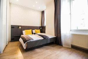 a bedroom with a bed with yellow pillows and a window at In the Hearth of the City Centre, Old Town Square - 3min in Prague