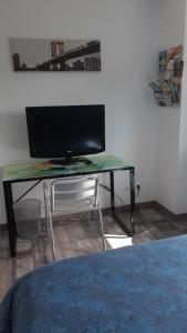 uma secretária com uma televisão e uma cadeira num quarto em Locabreizh 22 em Plourivo
