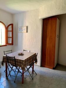ラ・カレッタにあるVilla Le Ginestreの木製のドア付きの部屋(テーブル、椅子付)
