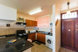a kitchen with a washer and a washing machine at La Ballito 402 in Ballito