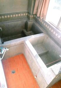 a bath tub with two sinks in a room at Royal Holiday Imv in Baihe