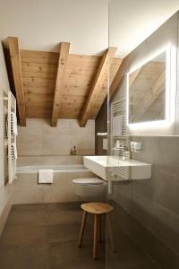 a bathroom with a sink and a toilet and a tub at Hotel Alpenland in Gstaad