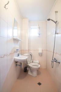 a white bathroom with a toilet and a sink at Guest House Roden Dom in Koprivshtitsa +62 photos