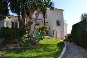 a white house with palm trees in front of it at Casa Ancladero Room W big balcony and lovely view in Fuengirola