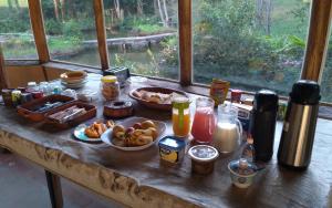 una mesa con comida para el desayuno y bebidas en ella en Vale do Sereno, en Paty do Alferes