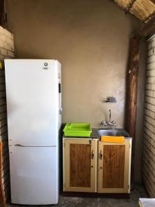 La cuisine est équipée d'un réfrigérateur blanc et d'un évier. dans l'établissement Motlopi Game Farm, à Thabazimbi