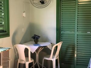 una mesa con sillas y un jarrón de flores. en hospedagem casa da wal quarto suíte en Goiás