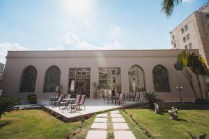 een gebouw met tafels en stoelen in een tuin bij Grand Pyramids Hotel in Caïro