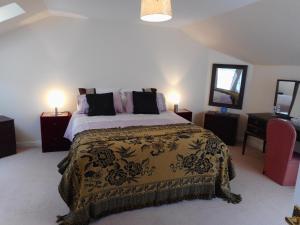 ein Schlafzimmer mit einem großen Bett und zwei Lampen in der Unterkunft DairyCottage, 5, TELFORD MEWS BEATTOCK in Moffat
