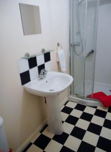 ein weißes Waschbecken in einem Badezimmer mit Dusche in der Unterkunft DairyCottage, 5, TELFORD MEWS BEATTOCK in Moffat + 12 Fotos