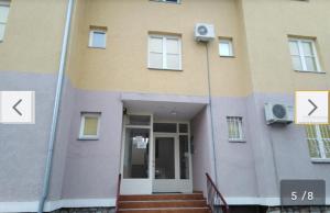 a large building with a door and stairs in front at Apartman LAZAR I VIKTOR in Vrnjačka Banja