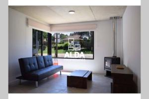 a living room with a blue couch and a tv at BAHIA SAN FRANCISCO, casa Albatros a 80 metros del mar, Uruguay in Piriápolis