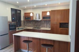 une cuisine avec des placards en bois et un comptoir blanc dans l'établissement Appartamento vacanza mare nel centro di Brolo, à Brolo