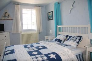 una camera con un letto e un piumone blu e bianco di Asphodèle ad Ambon