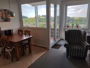 a dining room with a table and a chair and a window at Apartment Harzblick in Bad Lauterberg