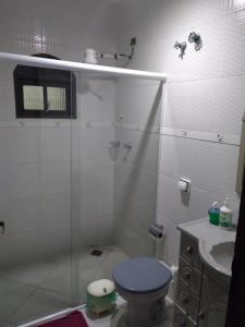 a bathroom with a shower and a toilet and a sink at Casacurral in Ilhabela