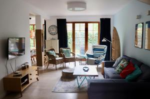 a living room with a couch and a table at Sea You Blue House in Rogowo