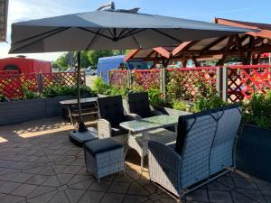 einen Tisch und Stühle unter einem Sonnenschirm auf einer Terrasse in der Unterkunft 1a Ferienwohnung in Weimar