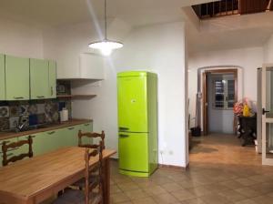 un frigorifero verde in una cucina con tavolo di Casa bella con terrazzo sul mare a Vietri