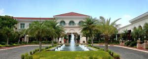 una casa con una fontana di fronte a un edificio di The Palms Town & Country Club - Resort a Gurgaon