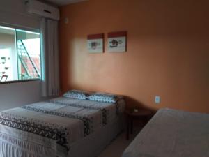 1 dormitorio con 2 camas y ventana en Pousada Canto Dos Passaros, en Pirenópolis