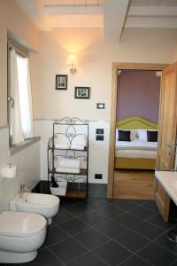 a bathroom with a toilet and a sink and a bed at La Terrazza di Reggello in Reggello