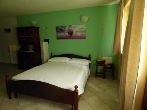 1 dormitorio con cama y pared verde en La Tana del Ghiro en Villefranche