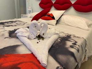 un letto con asciugamani e una testiera con cuori di Incanto del Garda a Monzambano