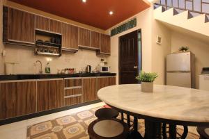 a kitchen with a table and a refrigerator at Vista Rio Melaka in Malacca