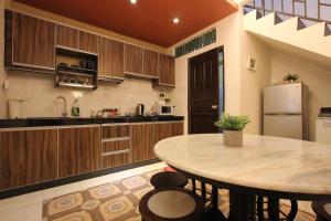 a kitchen with a table and a refrigerator at Vista Rio Melaka in Melaka