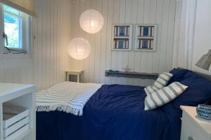 een slaapkamer met een blauw bed met 2 kussens bij Bergen, Huisje dat ademt zee en vakantie... in Bergen