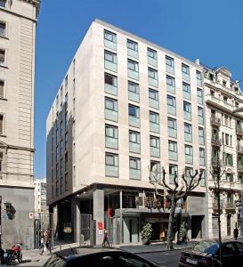 un gran edificio blanco en una calle de la ciudad en Evenia Rossello, en Barcelona