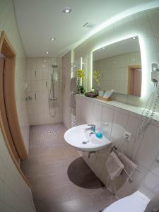 a bathroom with a sink and a mirror at Hotel - Restaurant - Metzgerei Sonne in Loffenau +33 photos