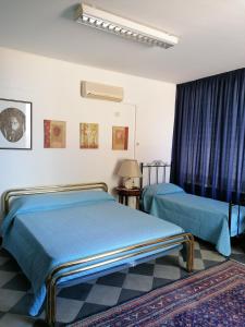 ポルト・エンペードクレにあるAl Caos Da Pirandello - Alloggio Vacanza Ufficioのベッド2台と窓が備わるホテルルームです。