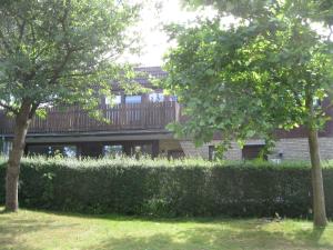 a house with a fence and trees in a yard at Ferienwohnung ULLABRU in Ascheffel