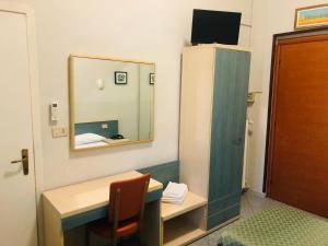 Kleines Zimmer mit einem Schreibtisch und einem Spiegel in der Unterkunft Hotel Ferrucci in Turin