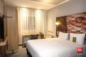 une chambre d'hôtel avec un lit et une télévision dans l'établissement ibis Quito, à Quito