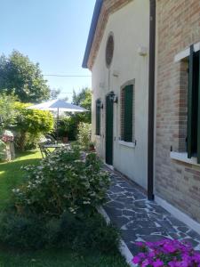 a walkway next to a building with purple flowers at Casa Pianta in Cavallino-Treporti