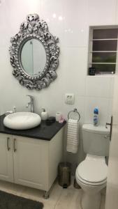 uma casa de banho com um lavatório e um espelho na parede em 513 on Mulberry em Pretoria